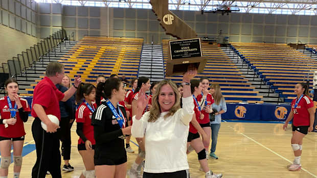 Glendale coach holds up 2023 CIF D4 girls volleyball state trophy by Michelle Bamford 11-18-23